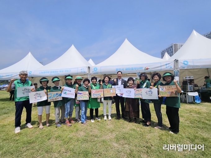용인시새마을회 회원들이 ‘제42회 대한민국연극제 광장축제’에서 먹거리 부스를 운영하고 기념촬영을 하고 있다.