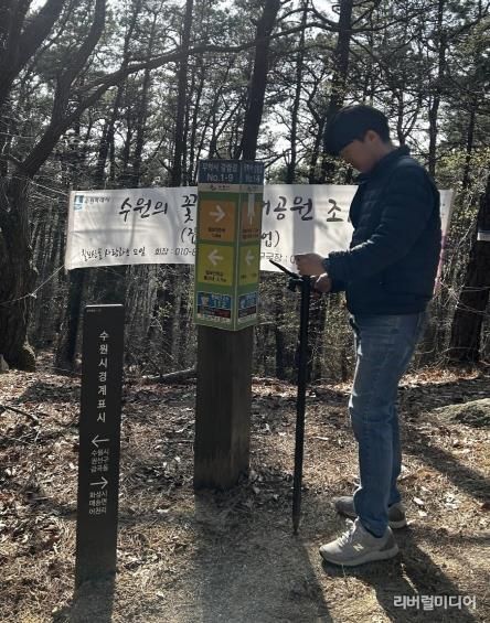 수원시 관계자가 GNSS를 활용해 칠보산 인근에 설치된 안내시설물의 위치정보를 측정하고 있다