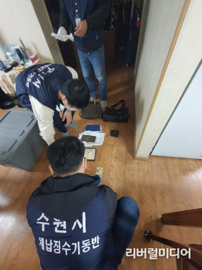 체납징수기동반 직원들이 체납자의 집을 수색하고 있다