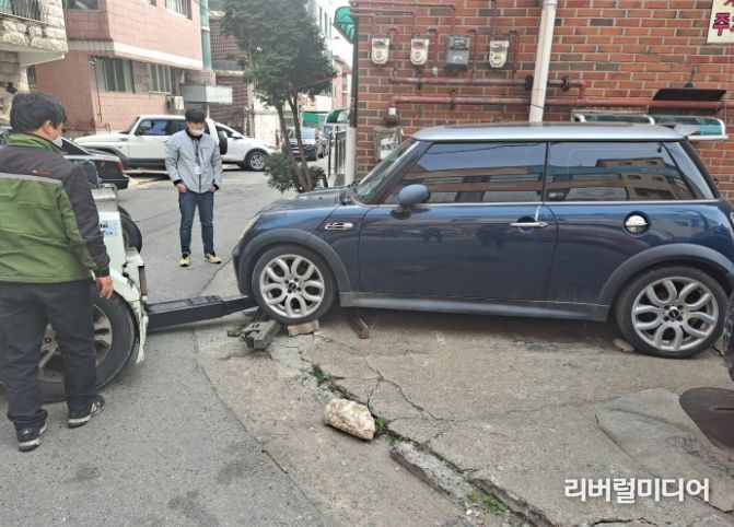 수원시 징수과 직원이 체납차량을 견인하고 있다