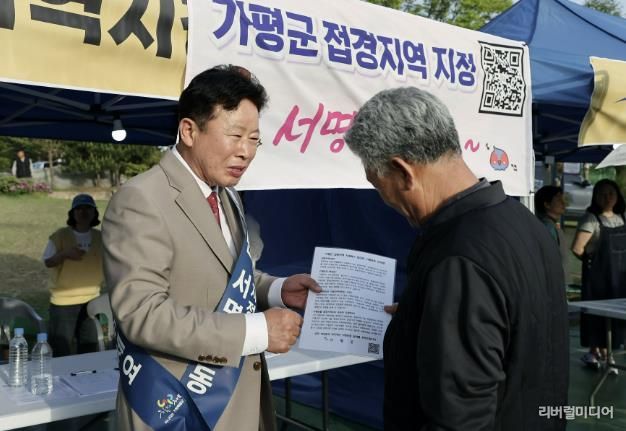 서태원 군수가 2024년 실시한 '범군민 서명운동'에서 주민으로부터 접경지역 서명을 받고 있다
