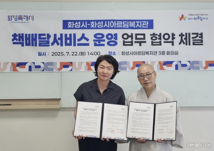 윤미영 화성특례시 도서관정책과장(사진 왼쪽)과 화성시아르딤복지관장 도선스님이 22일 책배달서비스 운영을 위한 업무협약을 체결하고 기념촬영하고 있다