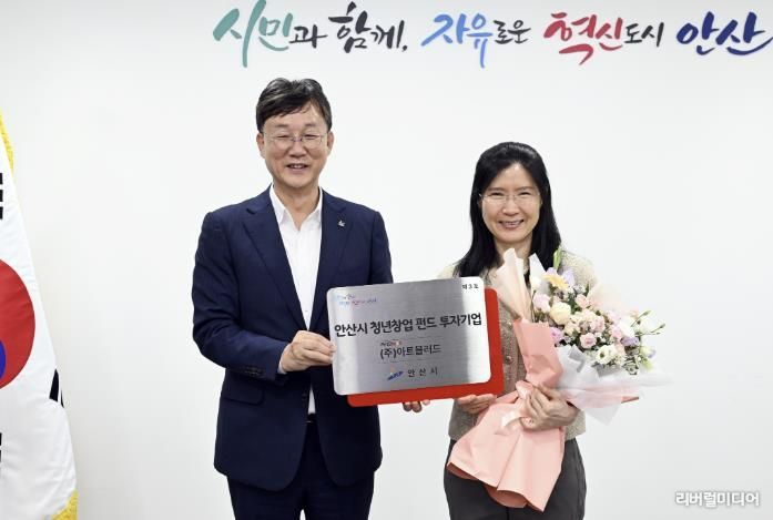 이민근 안산시장(왼쪽)이 백은정 ㈜아트블러드 대표에게 '안산시 청년창업 펀드 3호 투자기업' 현판을 전달하고 있다.