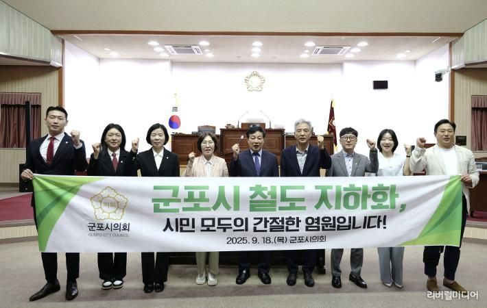 철도지하화 반영 요청 결의안 채택을 알리는 군포시의원들 모습.