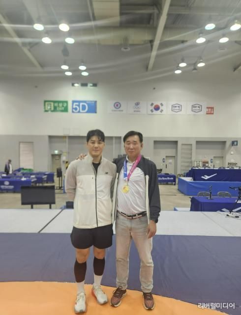 레슬링부 윤창희 감독과 김현우 선수가 기념사진을 찍고 있다.